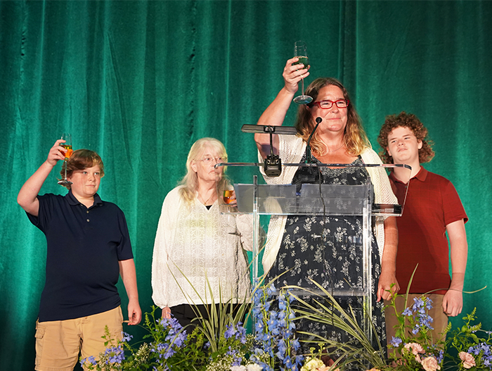 Woman and family drinking a toast on stage